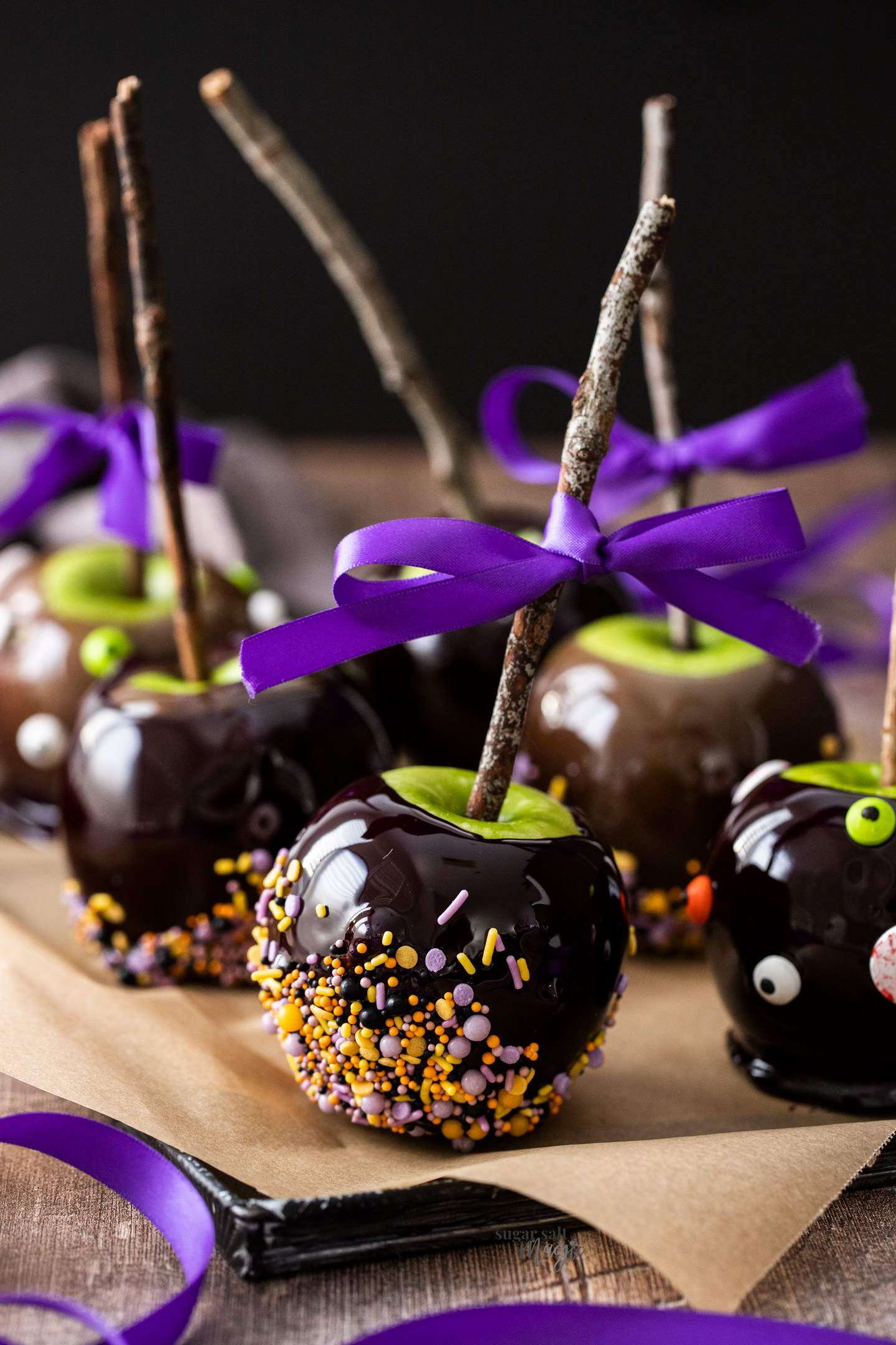 Candy apples on a tray with twigs stuck into the top.