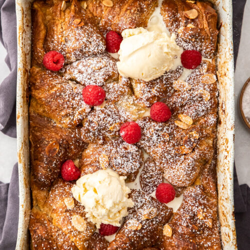 Top down view of croissant french toast casserole with ice cream and berries.