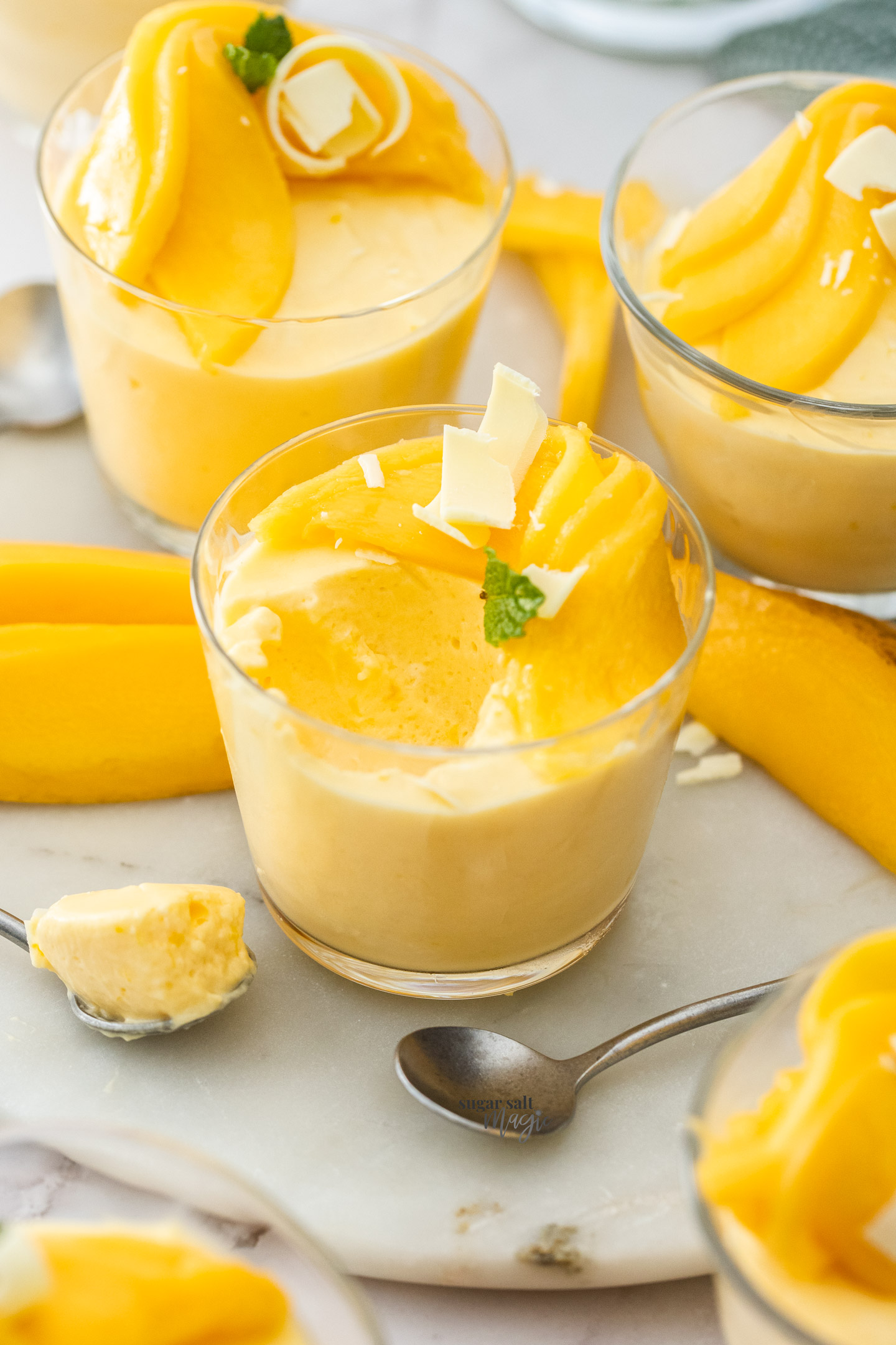 A glass of mango mousse with some taken out.
