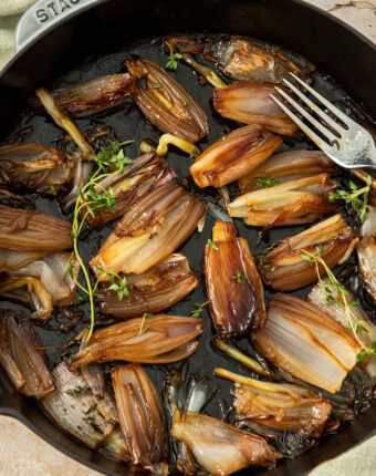Roasted shallots in a large skillet.