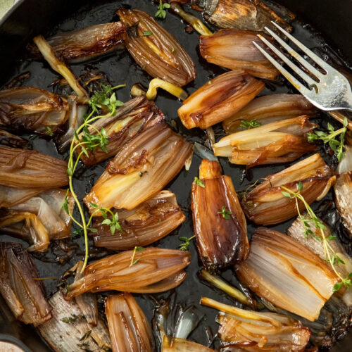 Roasted shallots in a large skillet.