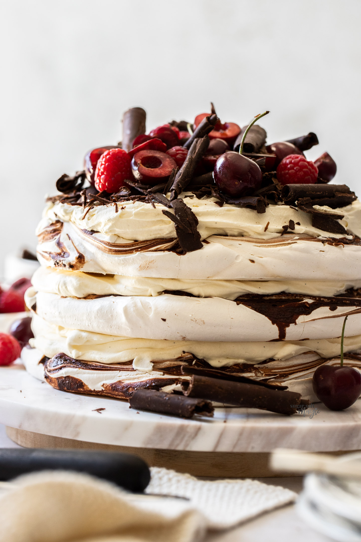 A 3 layered meringue cake with cream between the meringue layers.