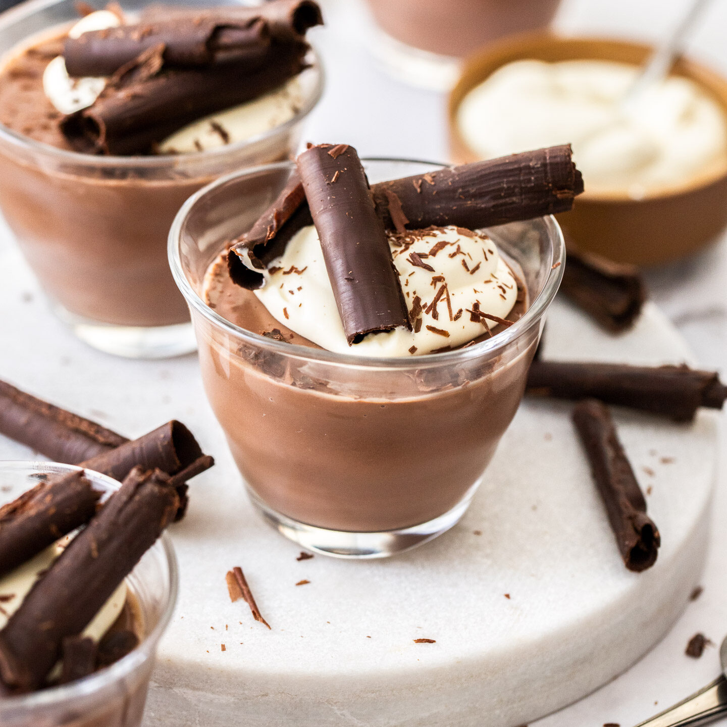 Chocolate pots topped with cream and chocolate curls.