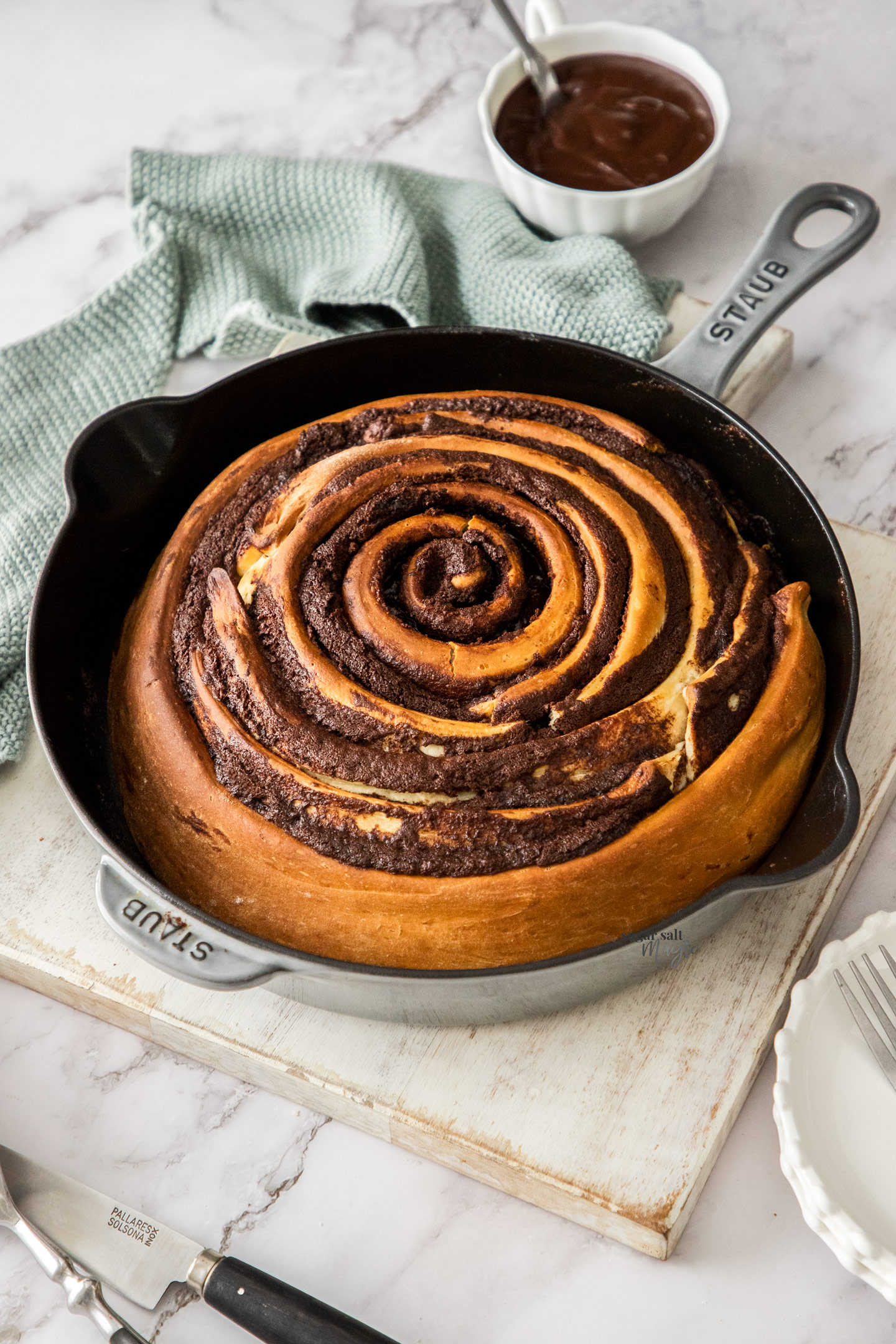 A giant chocolate scroll in a cast iron pan.