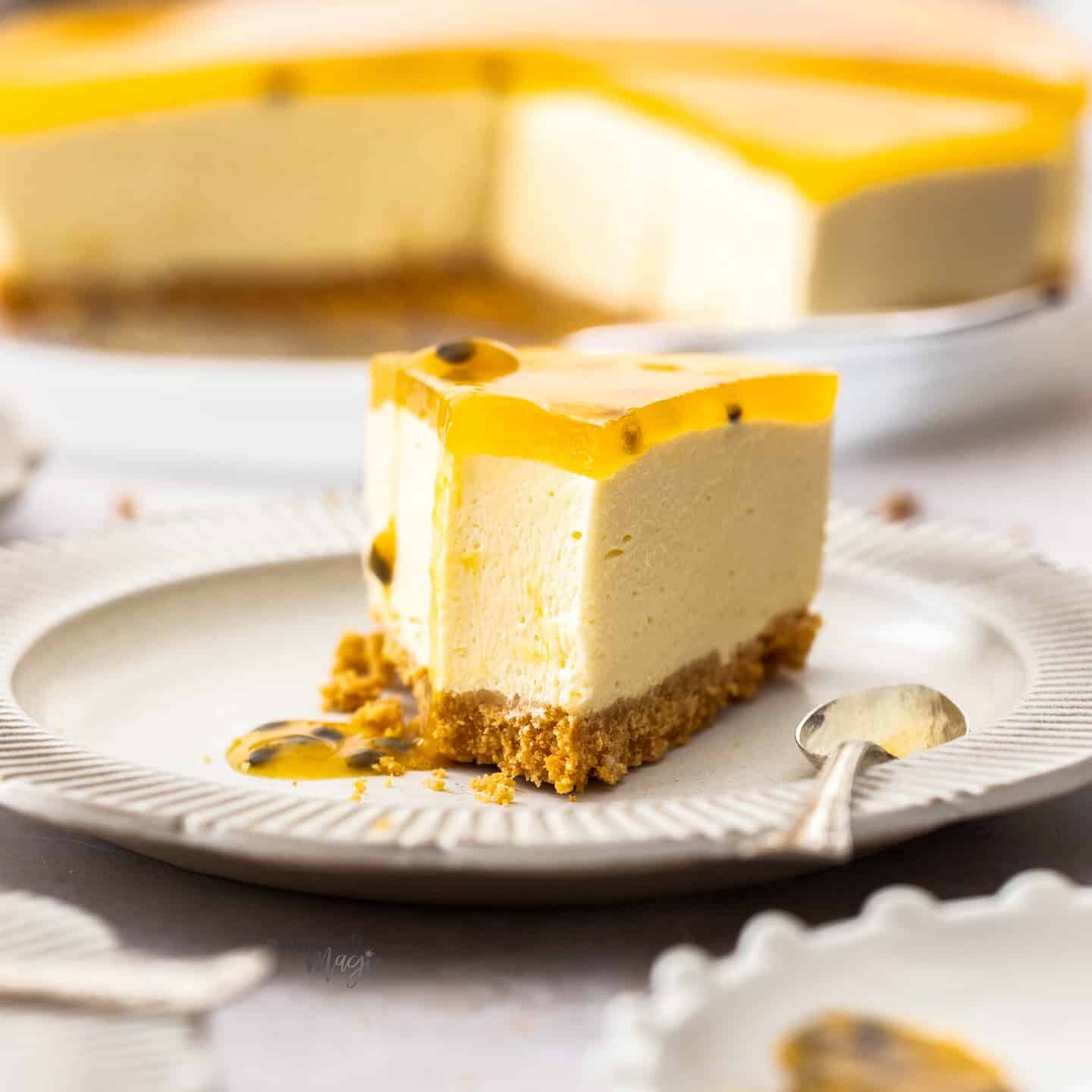 A slice of passionfruit cheesecake with a spoonful taken out of it.