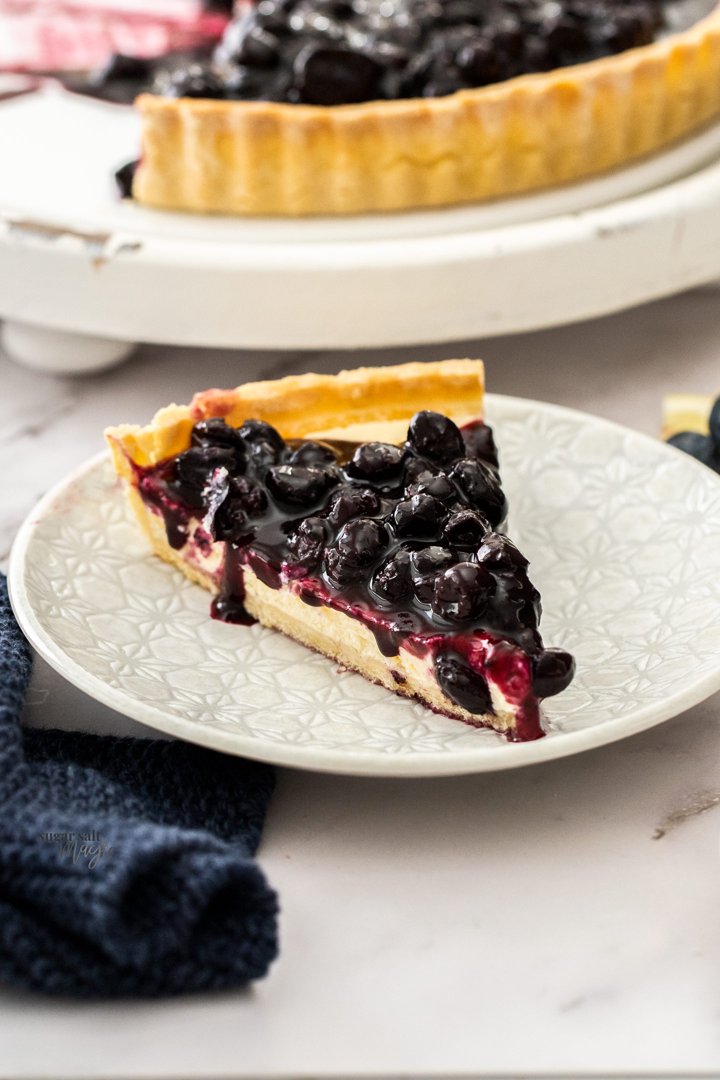 A slice of blueberry tart on a dessert plate.