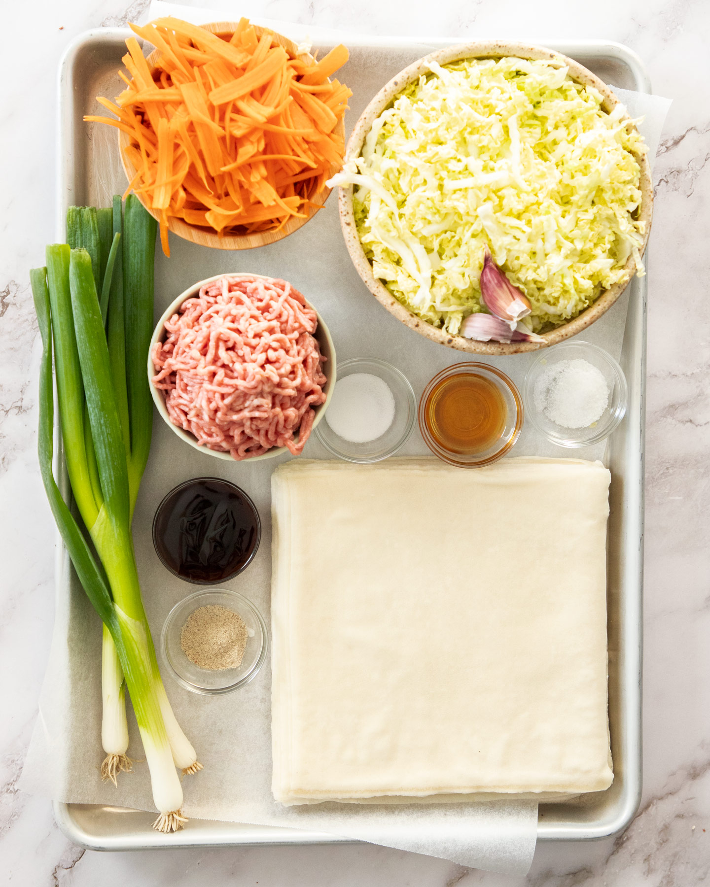 Ingredients for spring rolls on a baking tray.