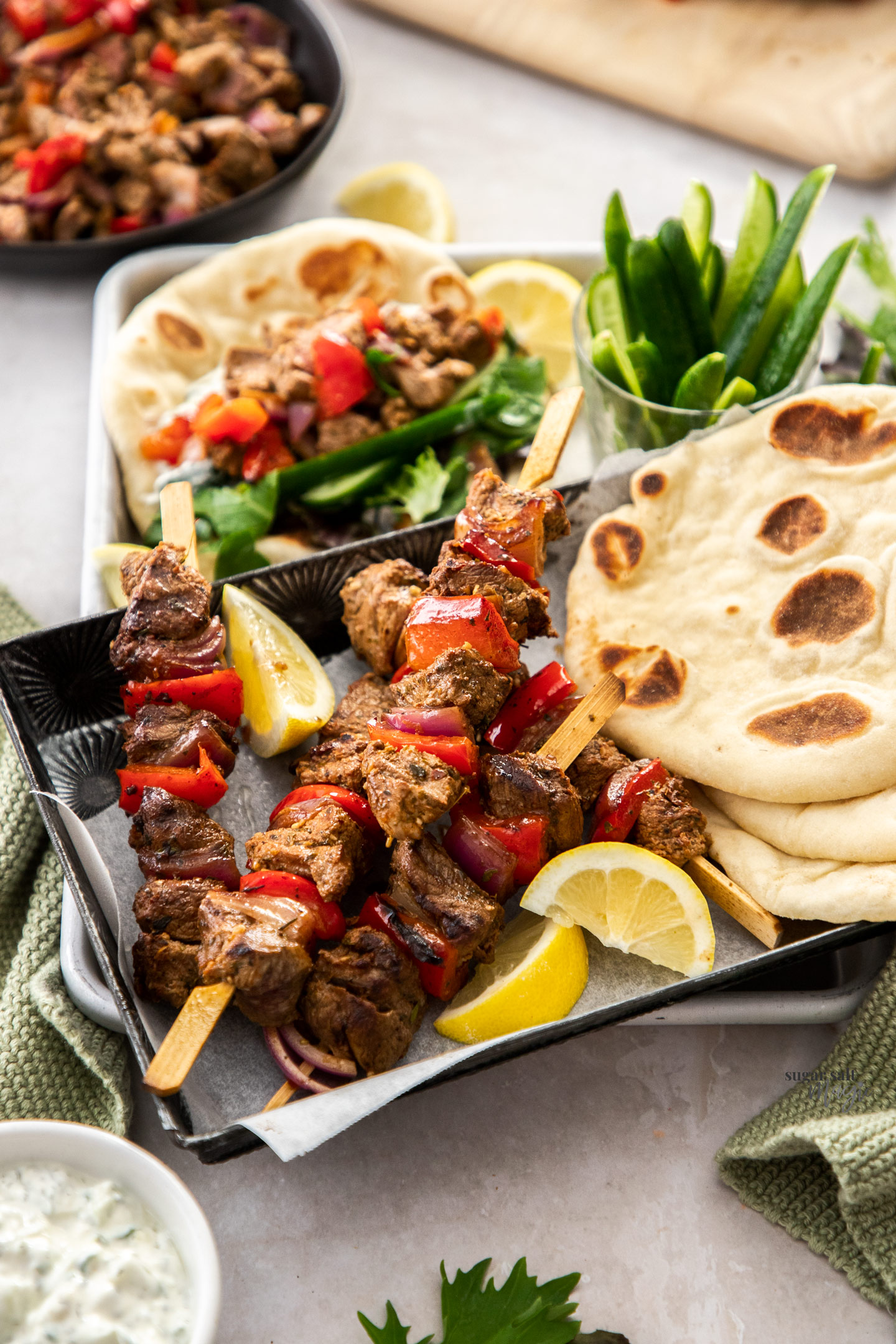 Lamb kebabs on a tray with pita bread.