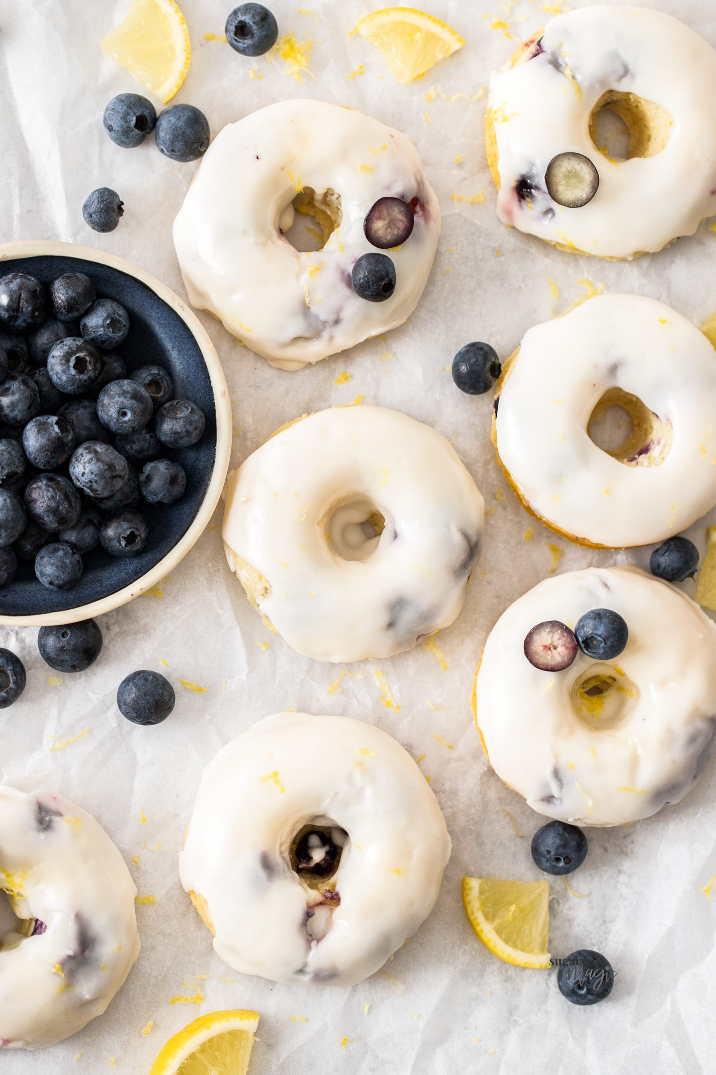 Top down view of 7 blueberry cake donuts with icing.