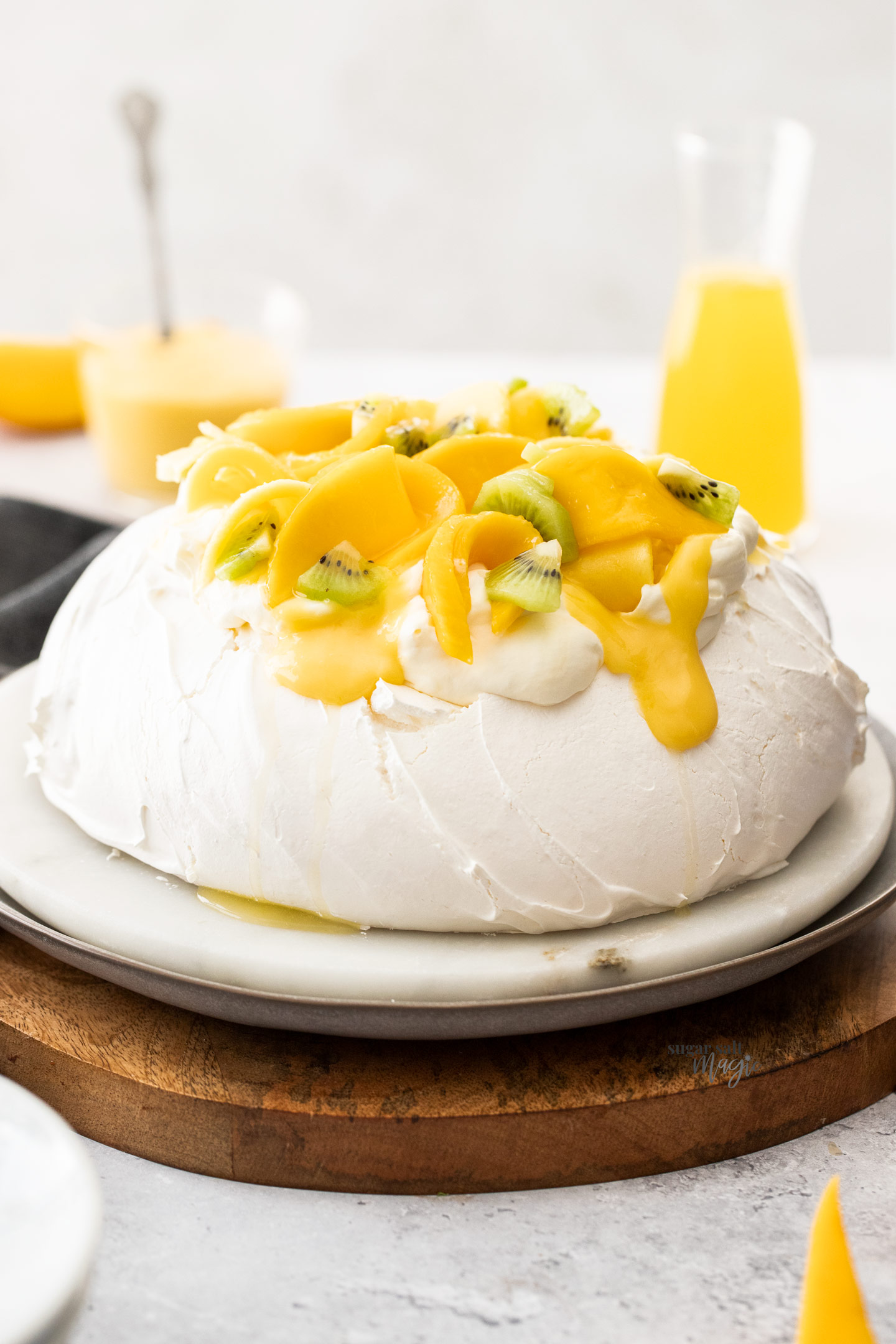 A whole pavlova topped with mango and cream.