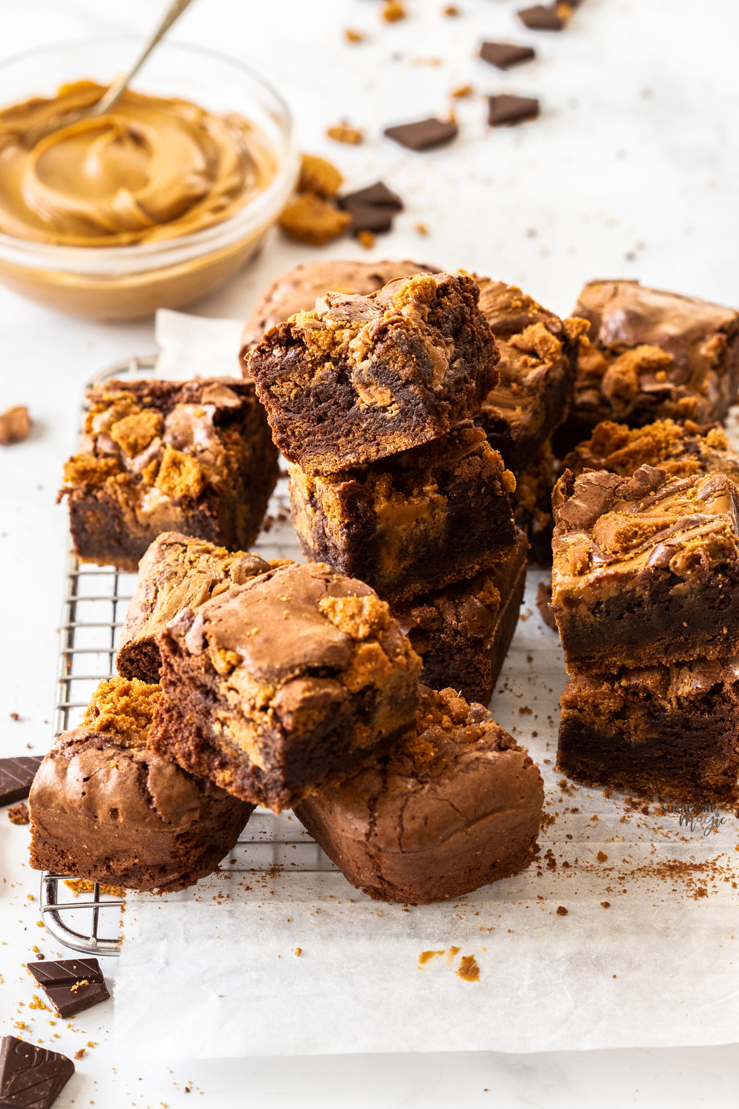 A batch of Biscoff brownies piled up on a wire rack.