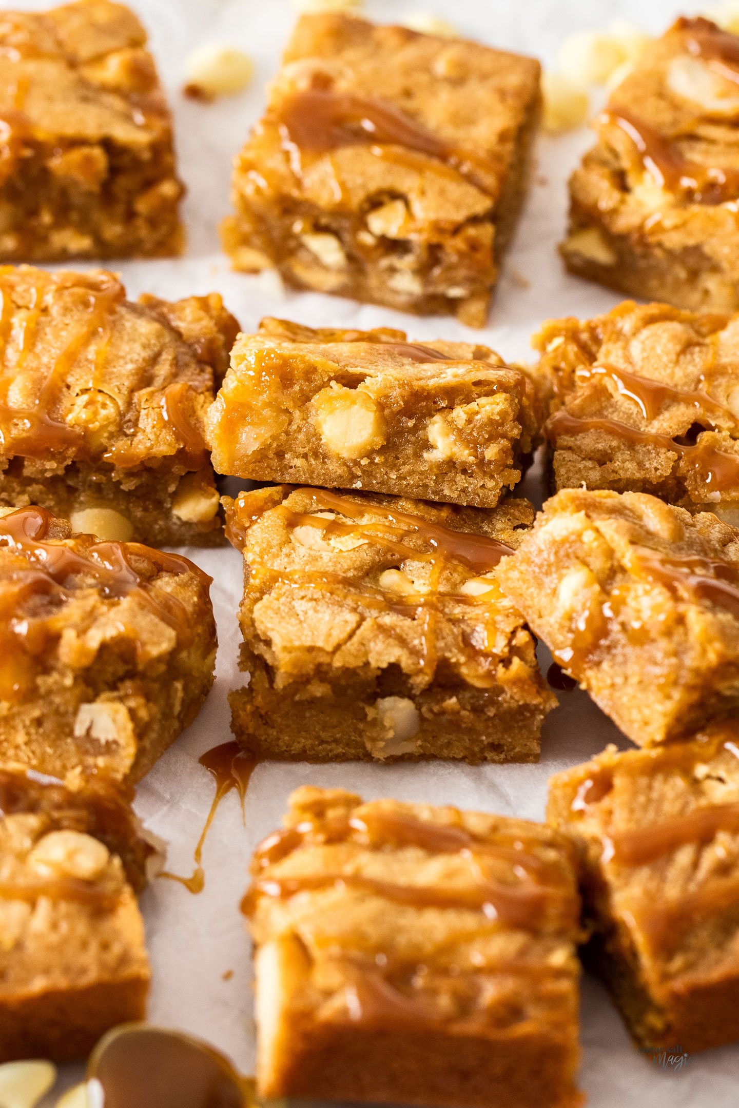 A pile of blondies drizzled with caramel.