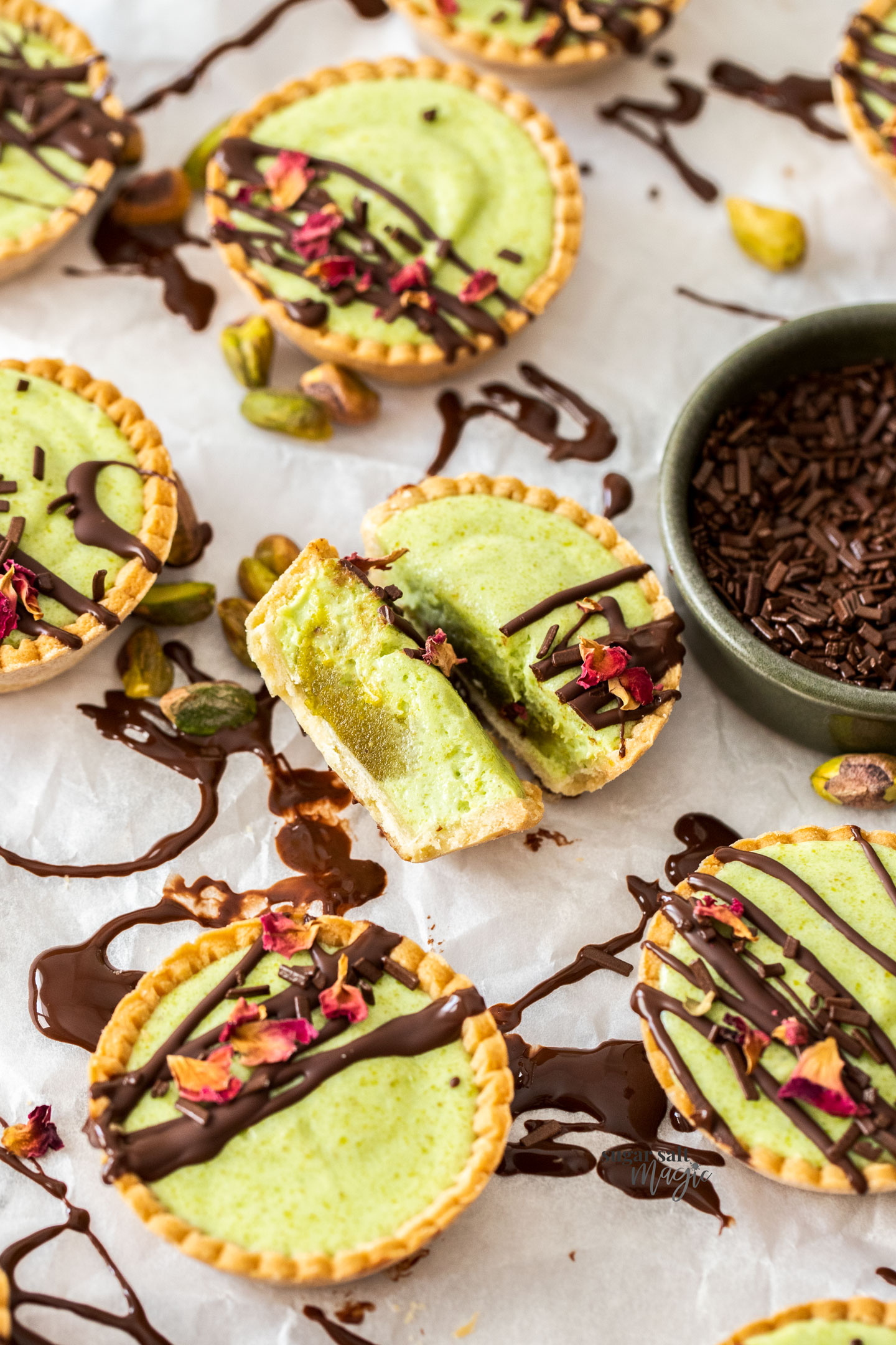 A pistachio tartlet chopped in half to show the filling inside.