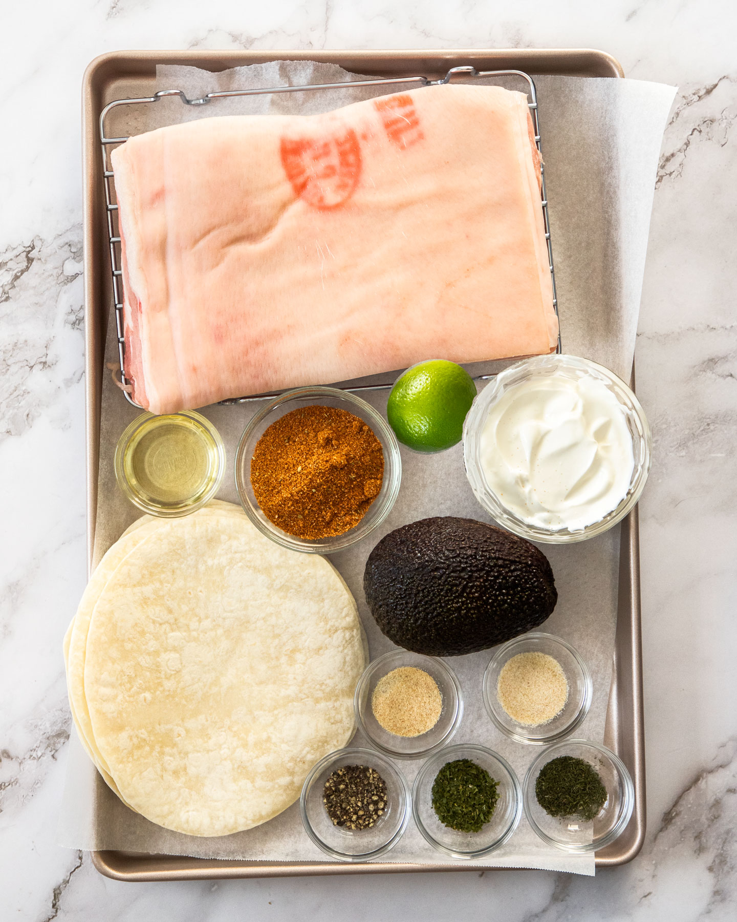Ingredients for pork belly tacos on a baking tray.