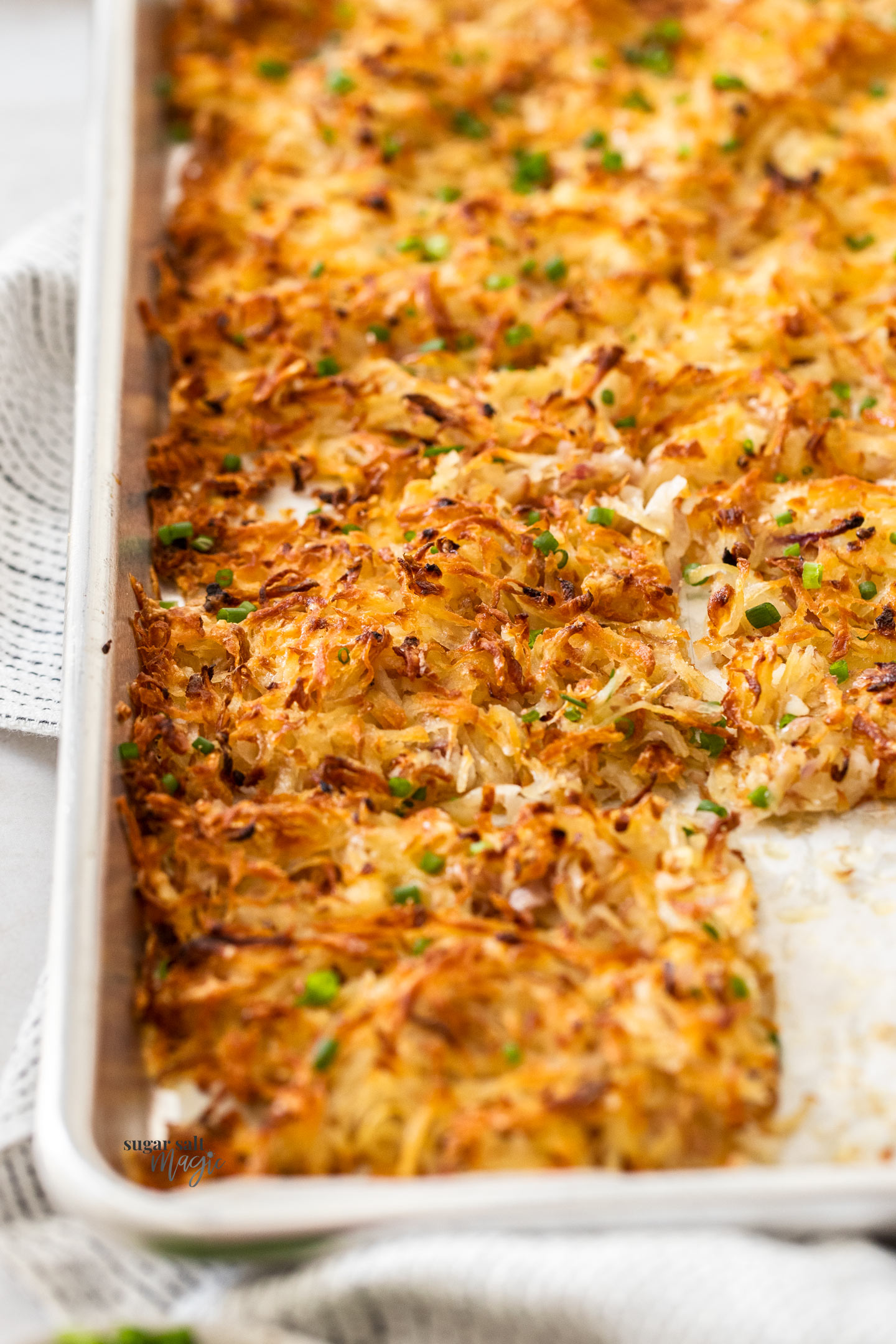 Closeup of baked hash browns in a baking sheet.