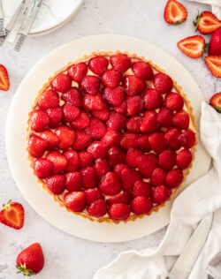 Top down view of a tart topped with fresh strawberries.