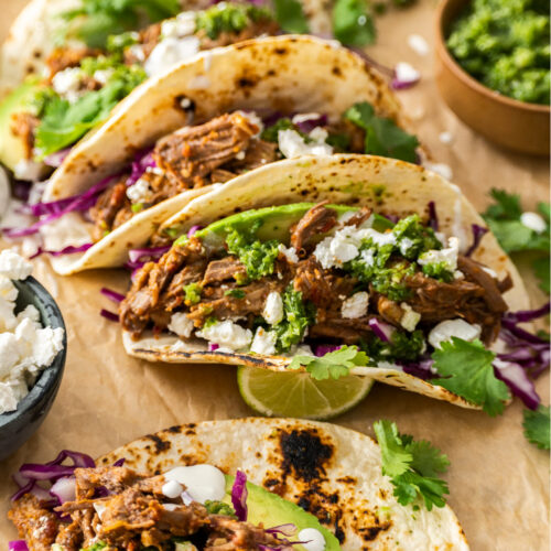 A batch of short rib tacos on sheet of parchment paper.
