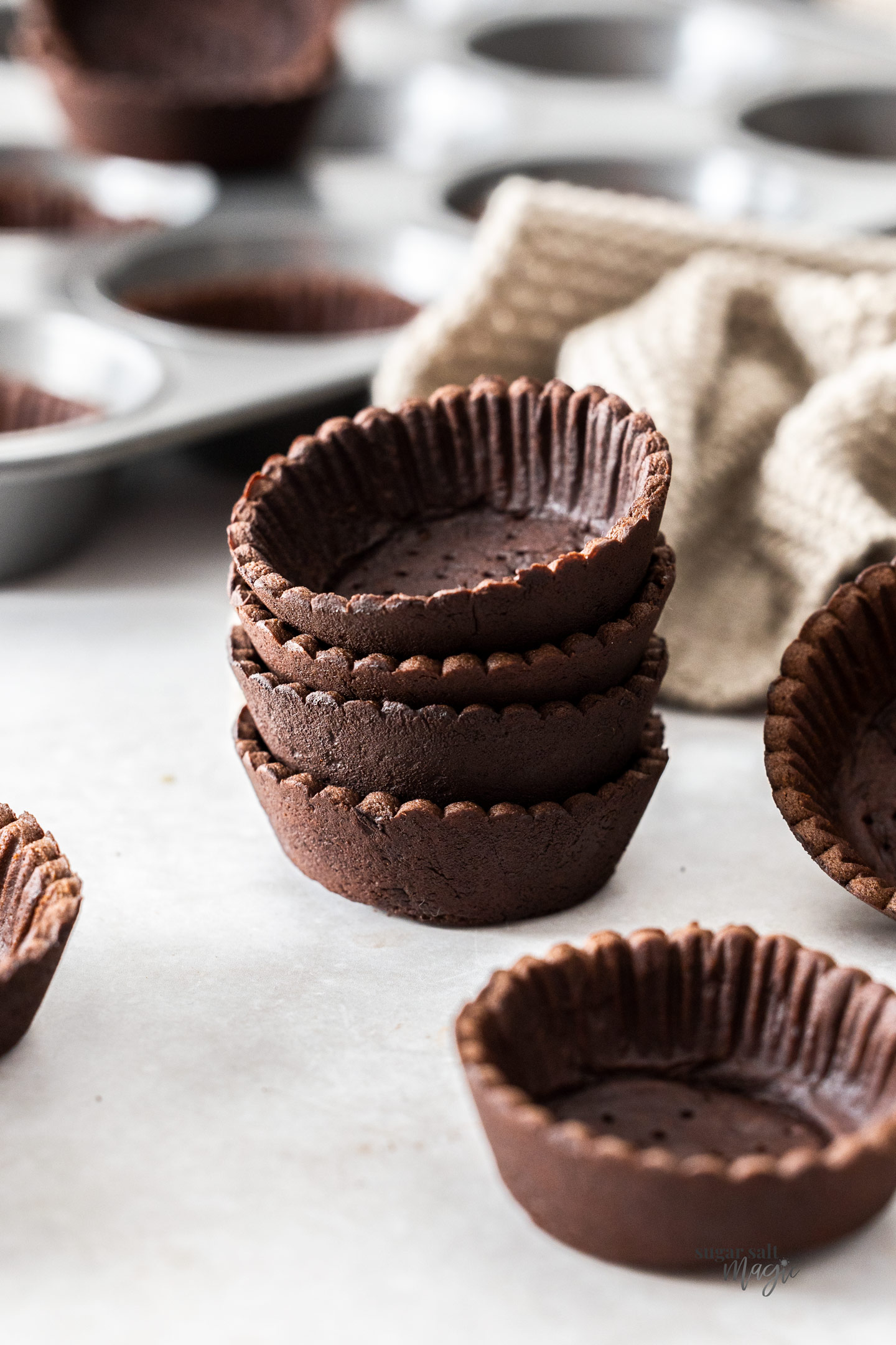 A stack of 4 chocolate tartlet shells.