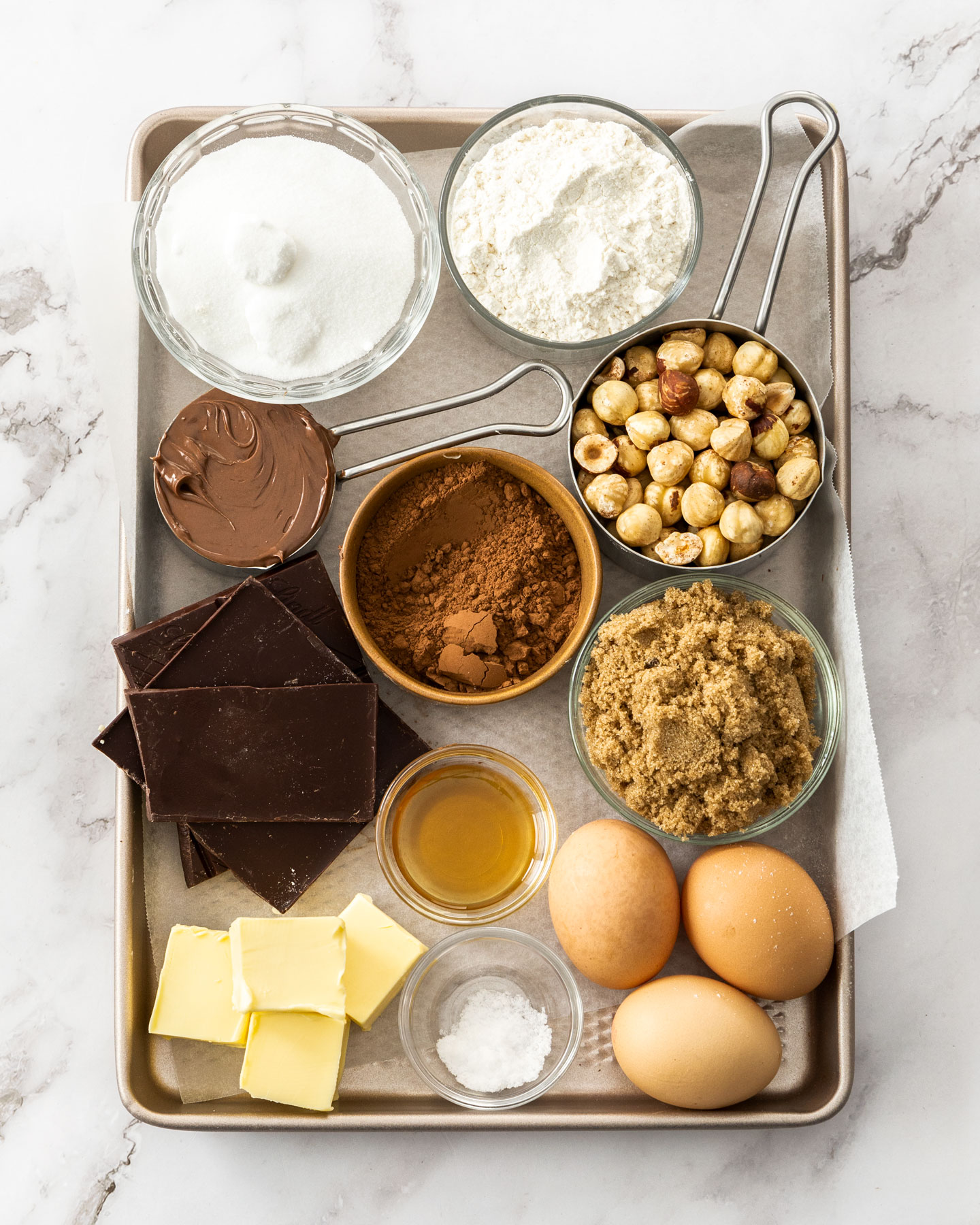Ingredients for hazelnut brownies on a baking tray.