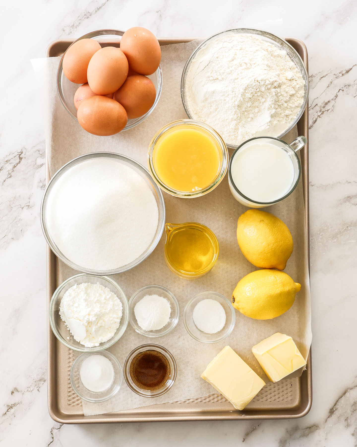 Ingredients for lemon meringue cake on a baking tray.