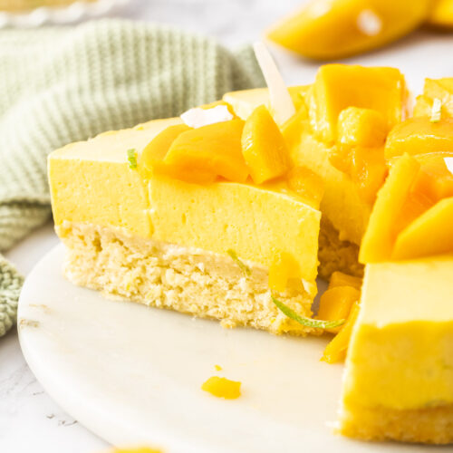 A sliced mango cake on a cake platter.