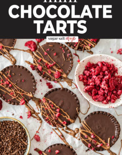 A batch of chocolate tarts with raspberries.