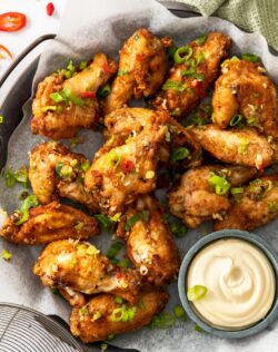 A batch of salt and pepper wings on a metal tray with Kewpie mayonnaise.