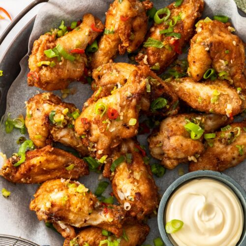A batch of salt and pepper wings on a metal tray with Kewpie mayonnaise.