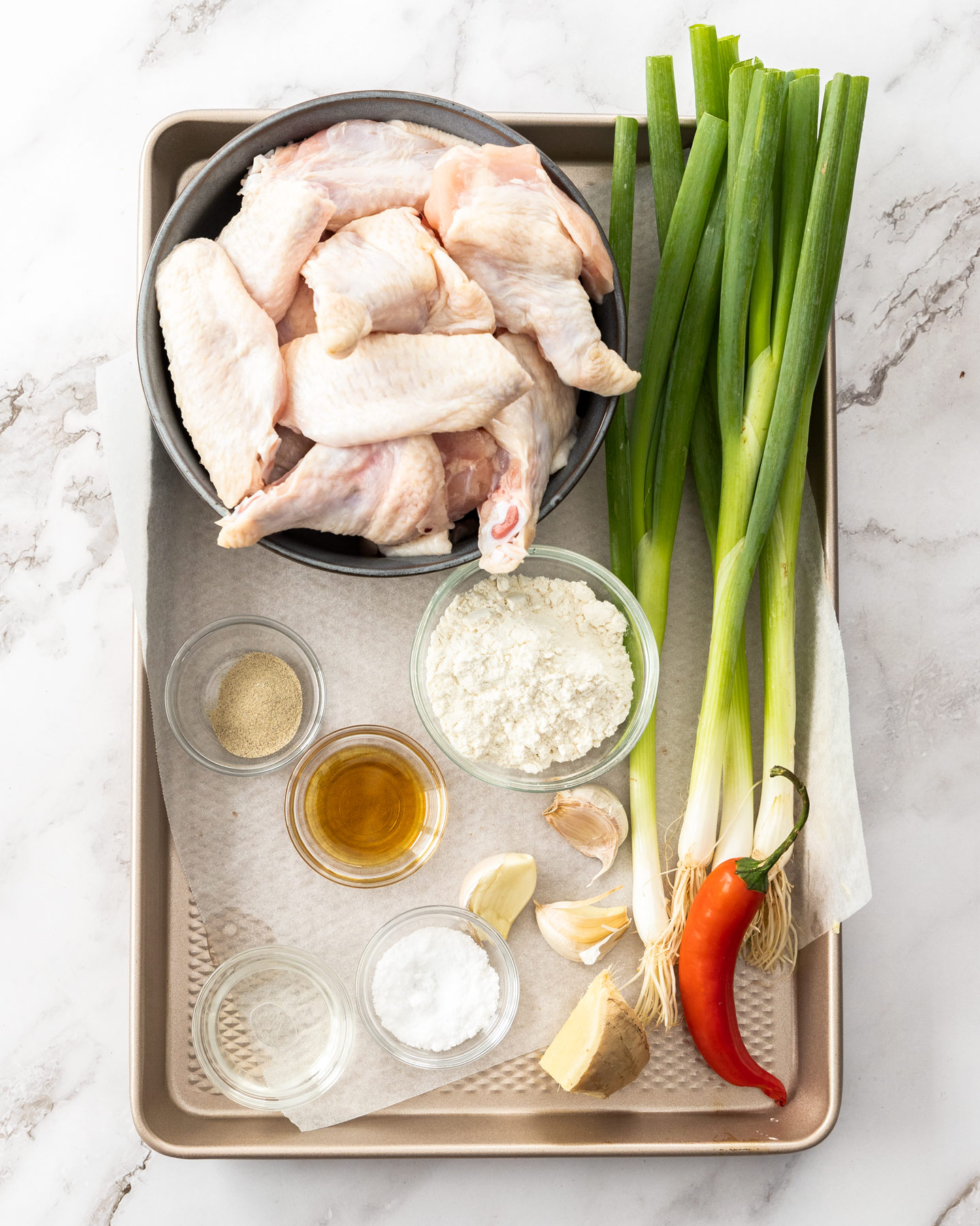 Ingredients for salt and pepper wings on a baking tray.
