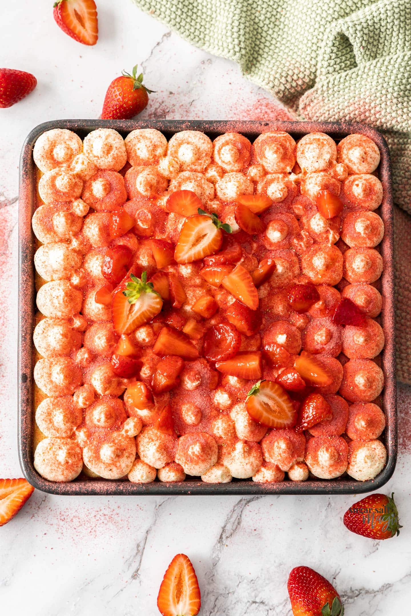 Top down view of strawberry tiramisu in a baking pan.