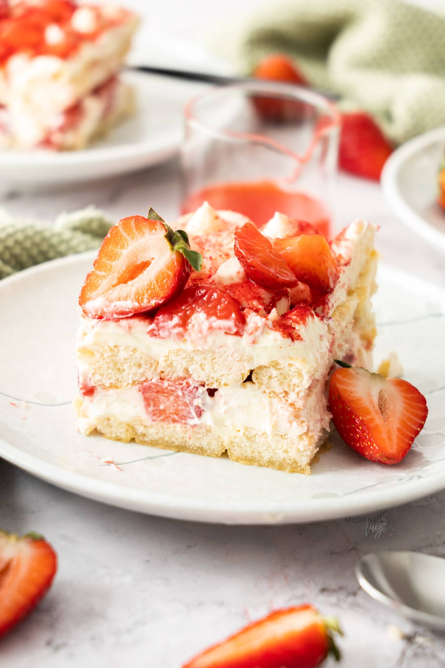 A square slice of strawberry tiramisu on a dessert plate.