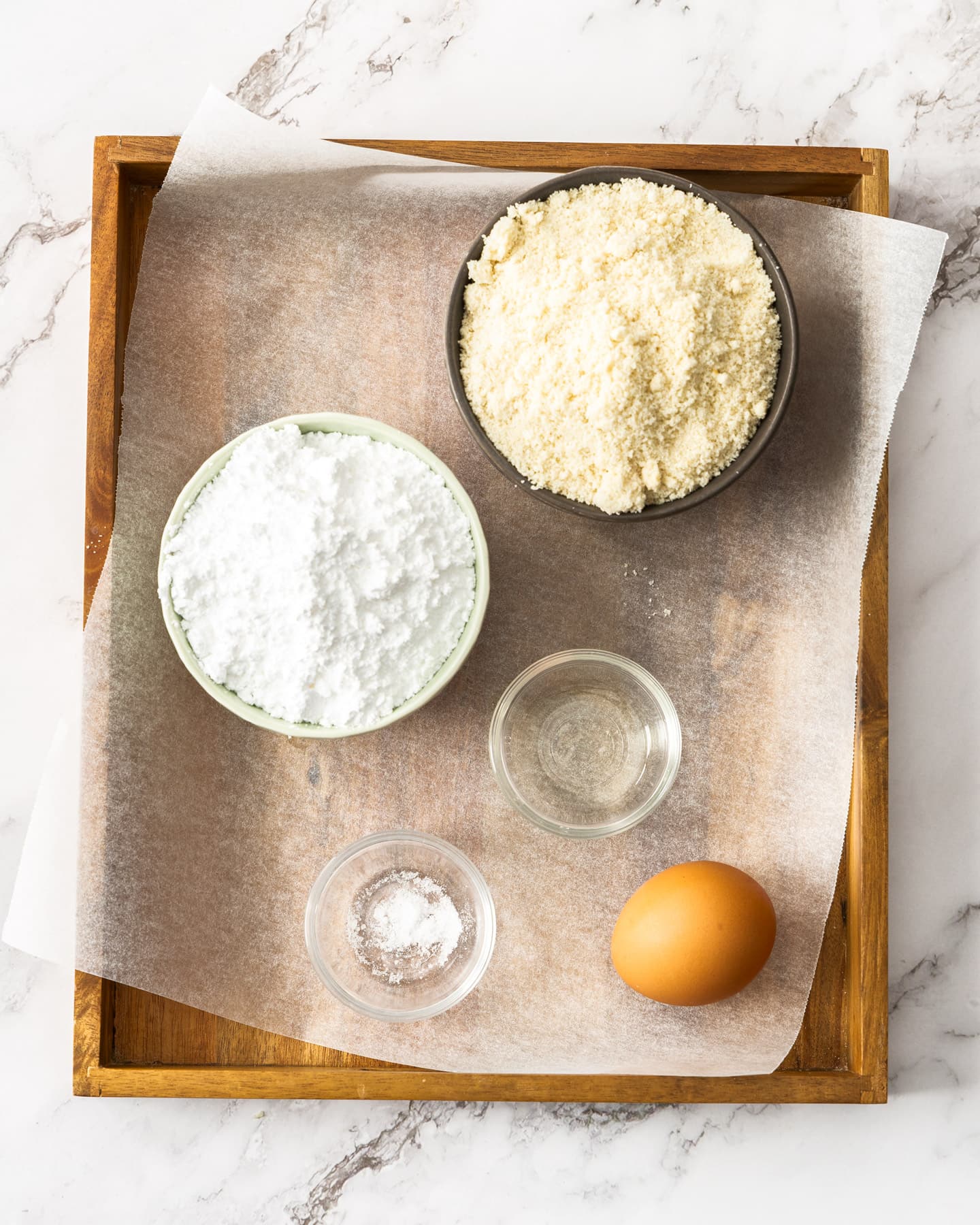 Ingredients for almond paste on a wooden tray.