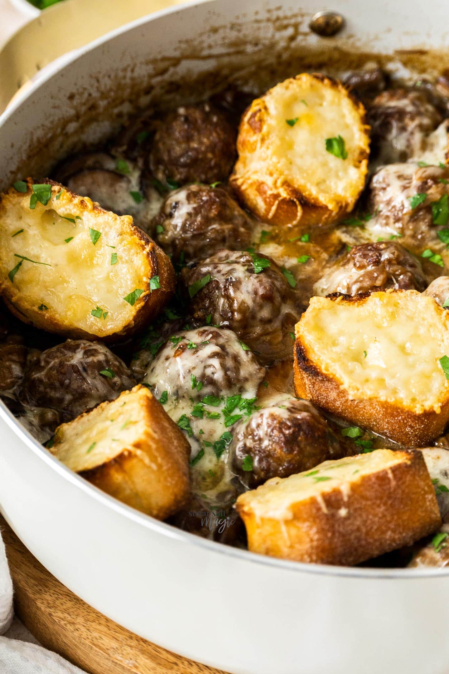 Closeup of the French onion meatballs with melted cheese over the top.