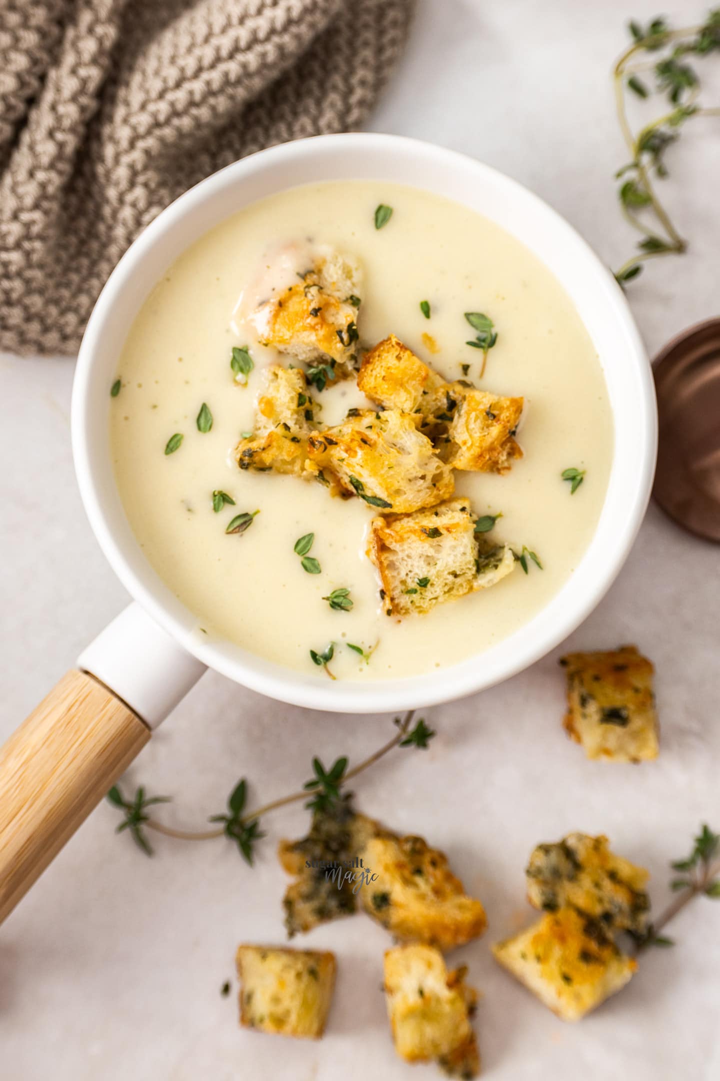 Top down view of potato chowder with croutons in a soup bowl.