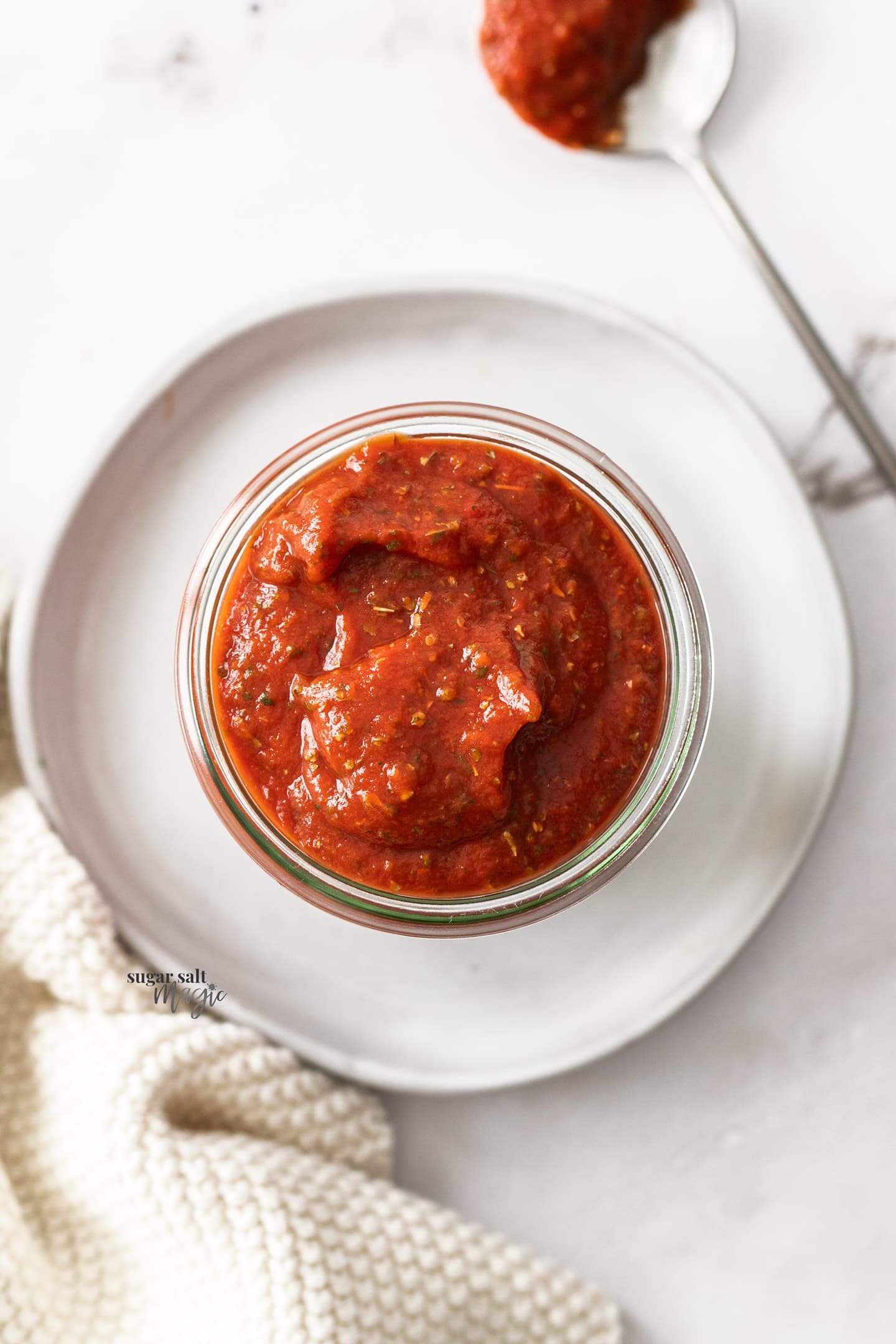 Pizza sauce in a glass jar - top down view.