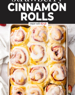 12 strawberry cinnamon rolls on a baking tray.