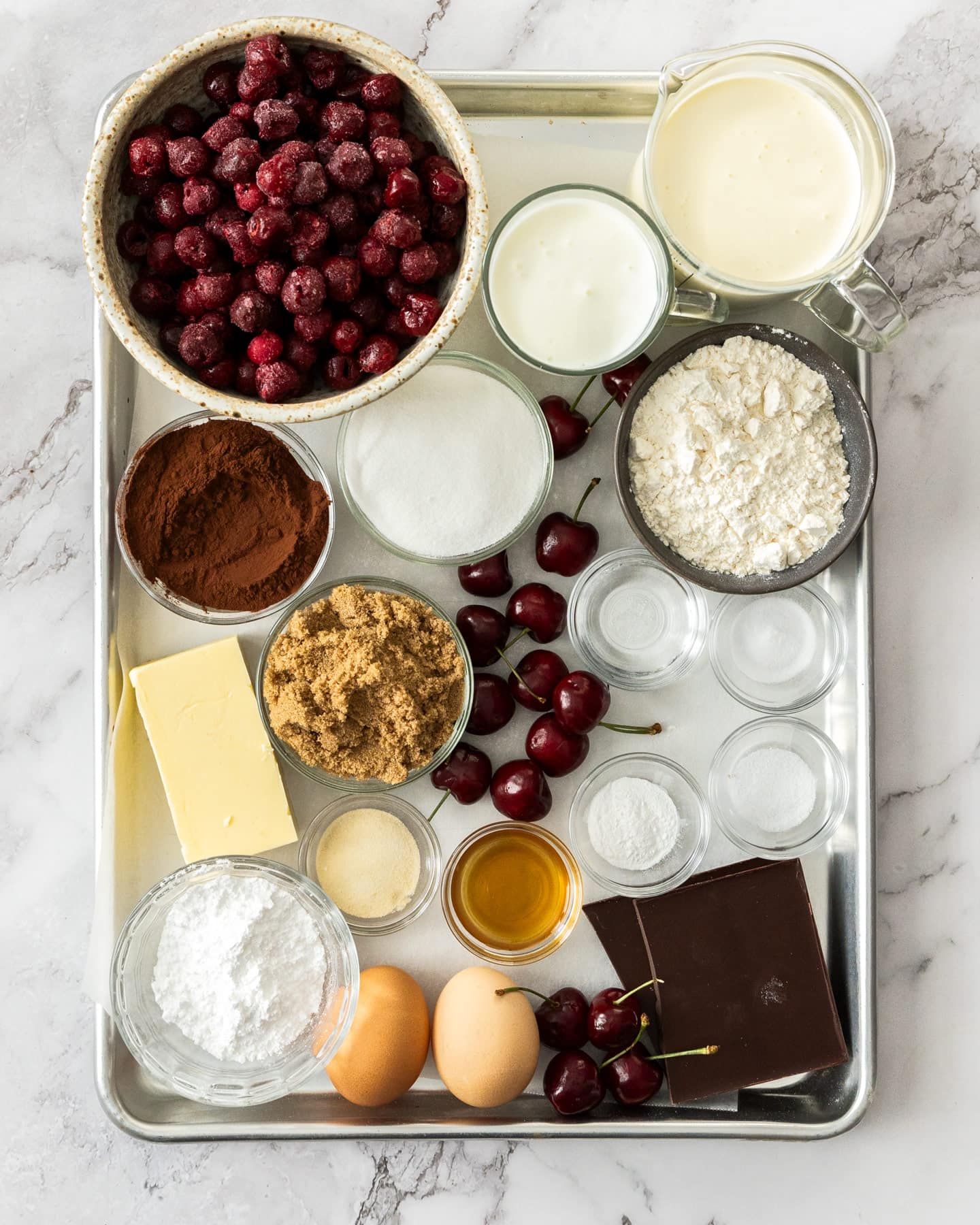 Ingredients for black forest cupcakes on a baking sheet.