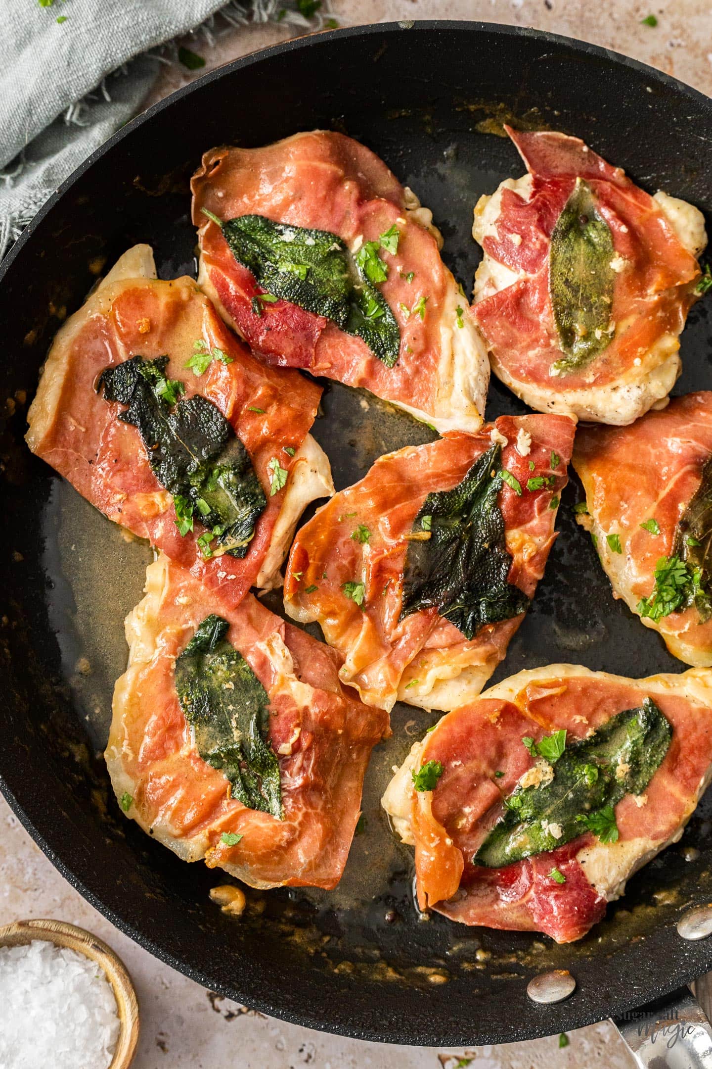 7 pieces of saltimbocca chicken in a skillet.