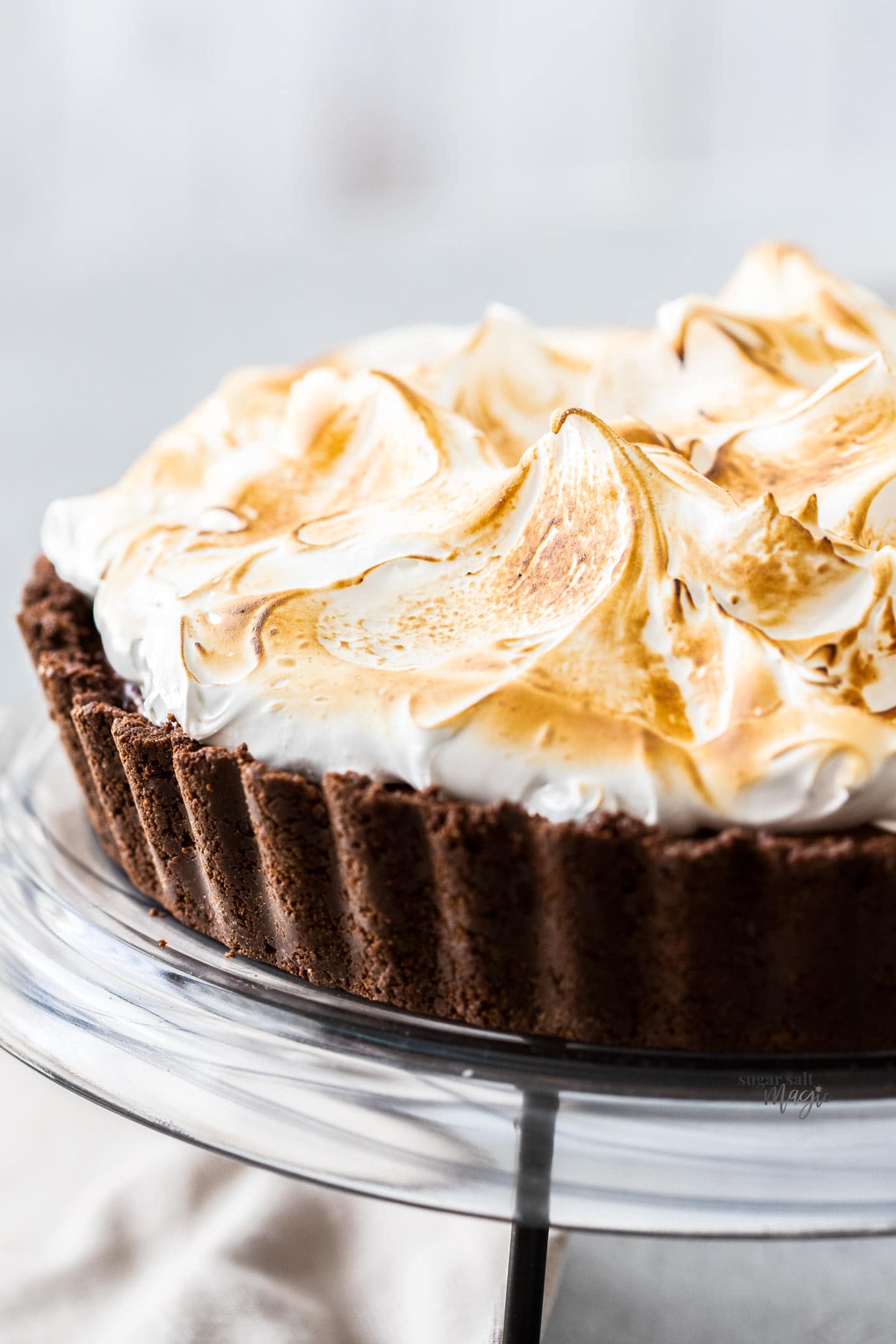 Closeup of chocolate meringue pie on a cake platter.