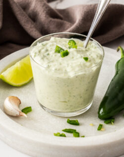 A glass filled with jalapeno mayo.