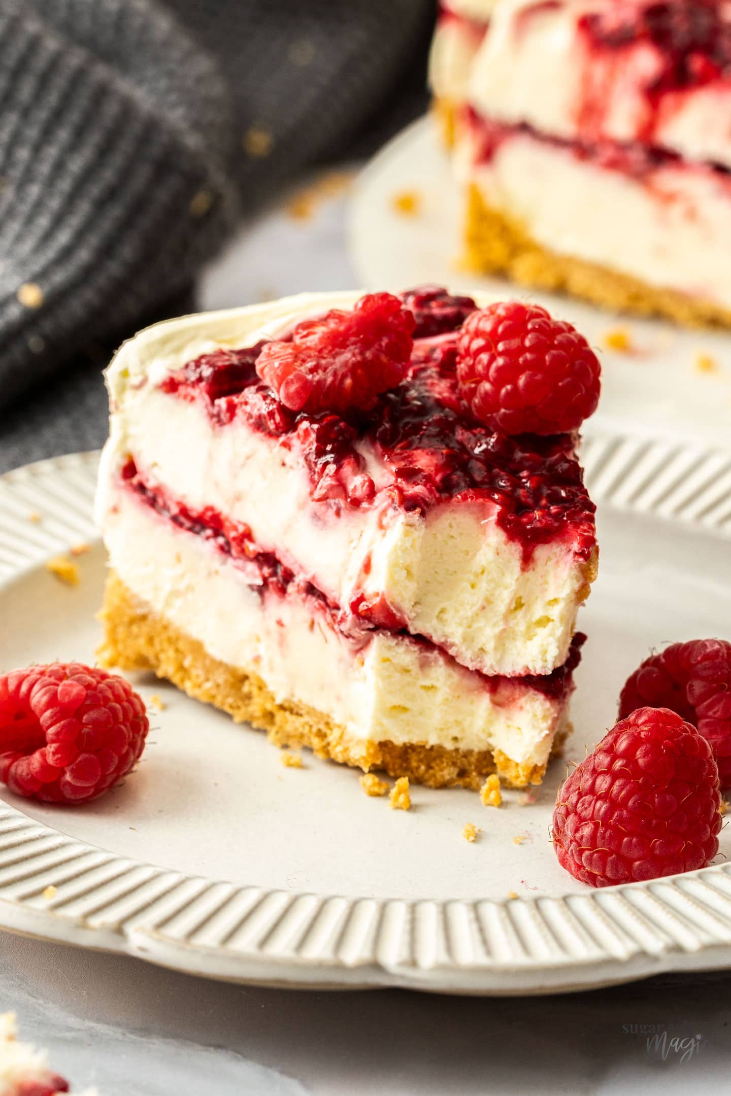 A slice of raspberry cheesecake with a forkful removed.