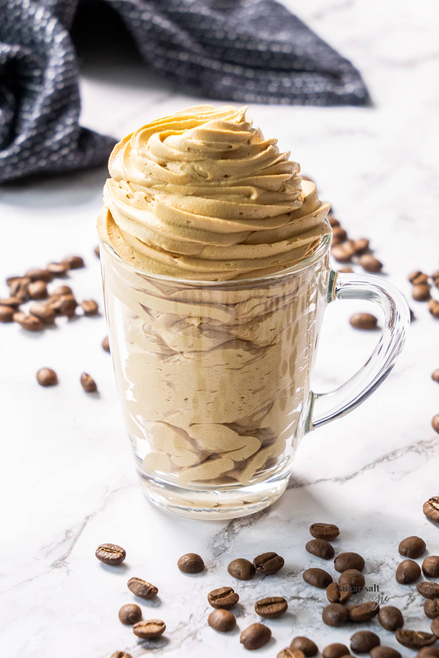 Coffee buttercream piped into a coffee glass.