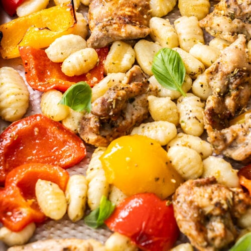 Closeup of chicken and gnocchi on a baking tray.