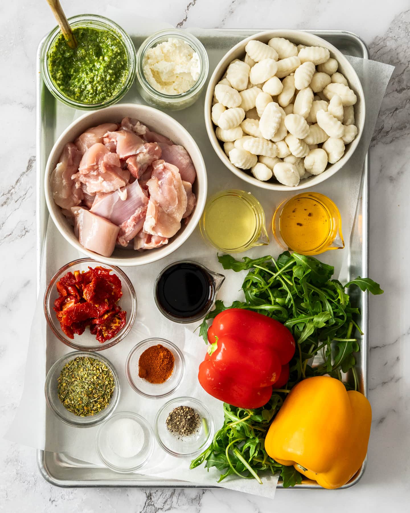 Ingredients for Italian chicken tray bake on a baking tray.