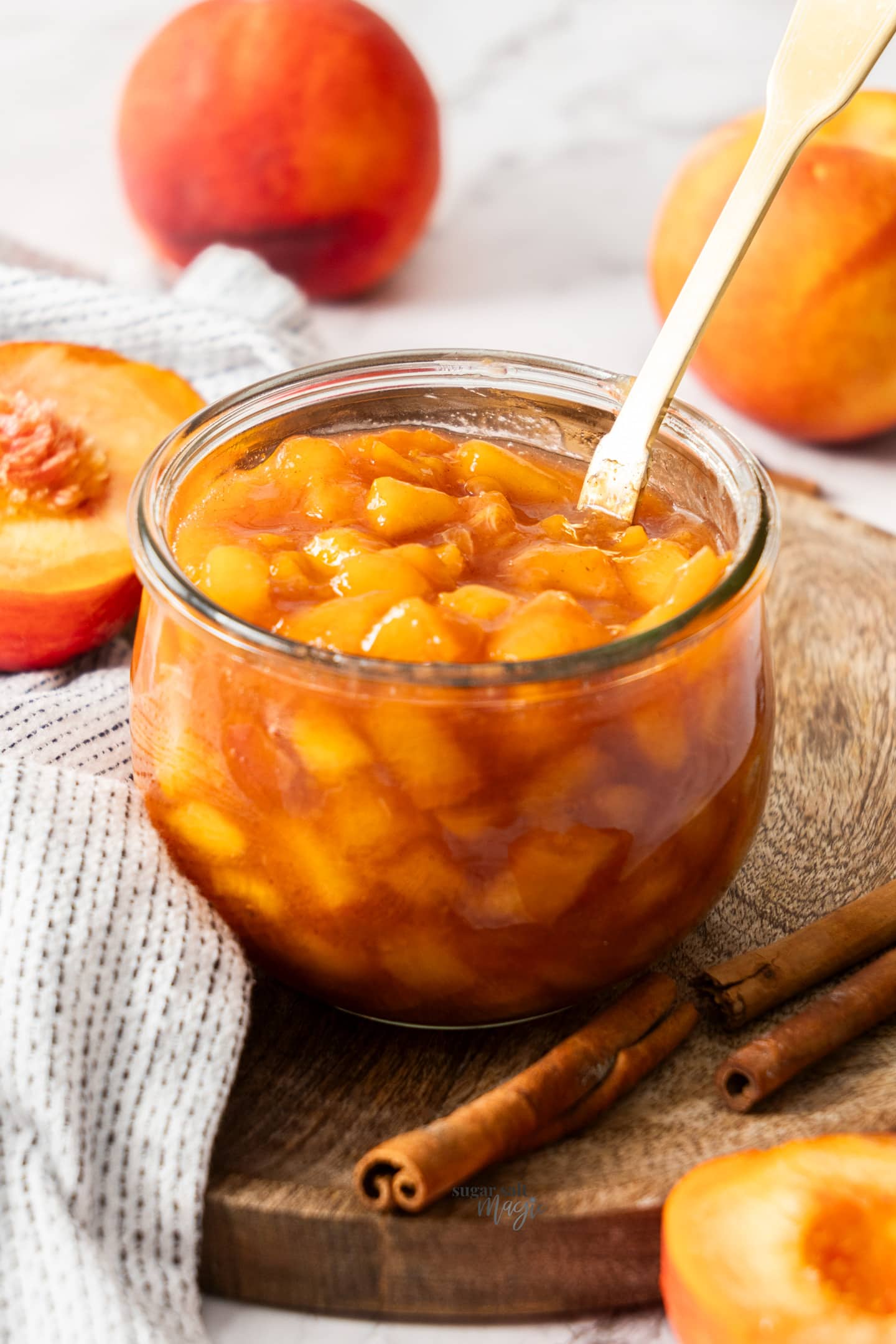 A glass jar filled with peach compote.