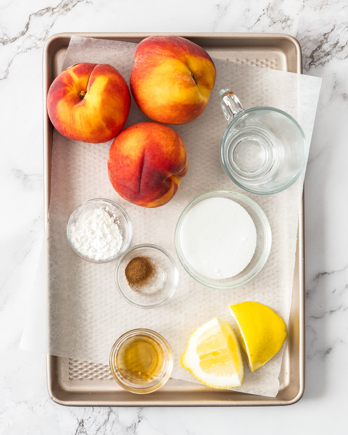 Ingredients for peach compote on a baking tray.
