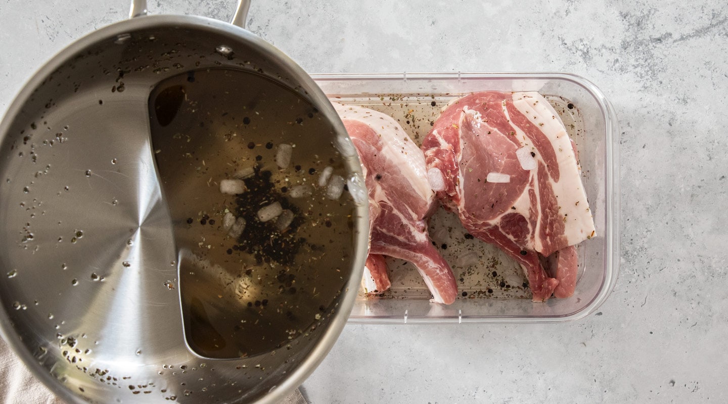 The brine being poured over pork chops.