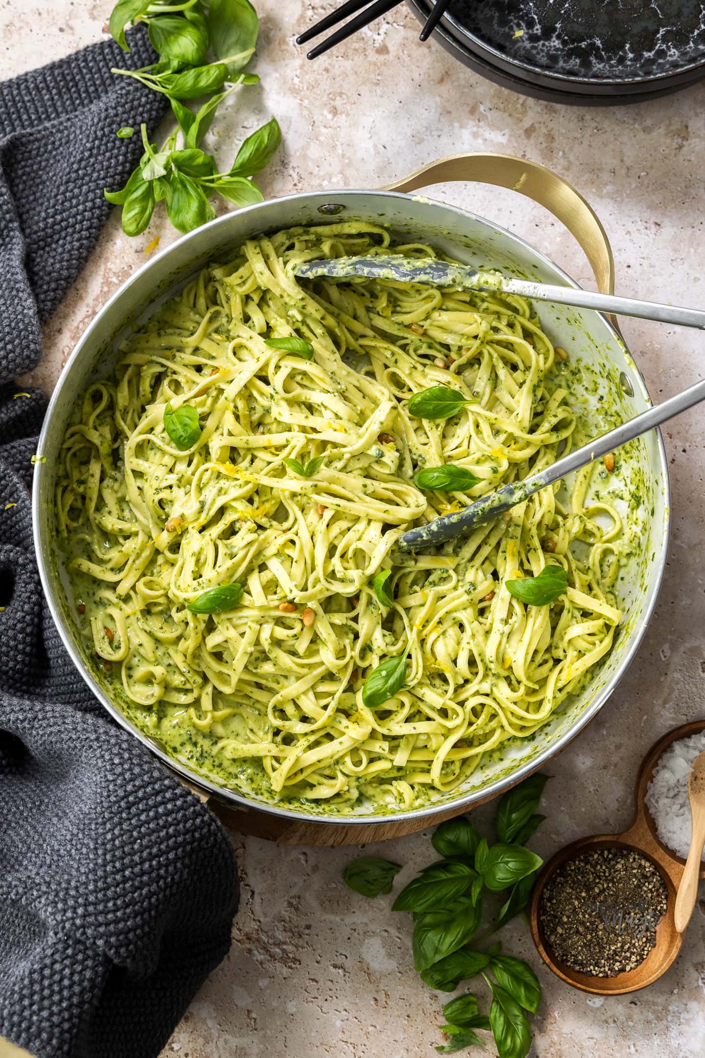 A deep skillet filled with creamy pesto pasta.