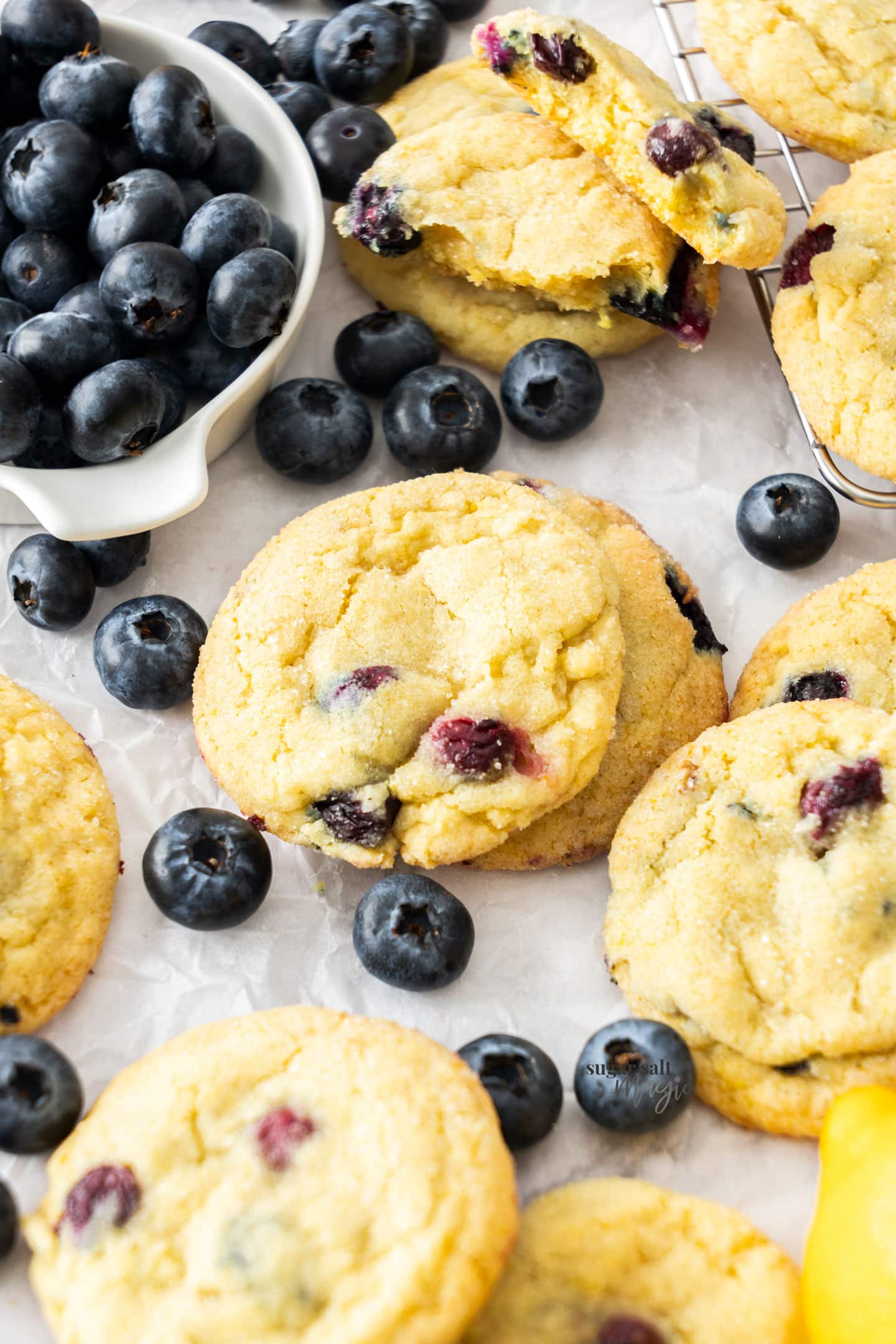 A couple of stacked cookies surrounded by blueberries.