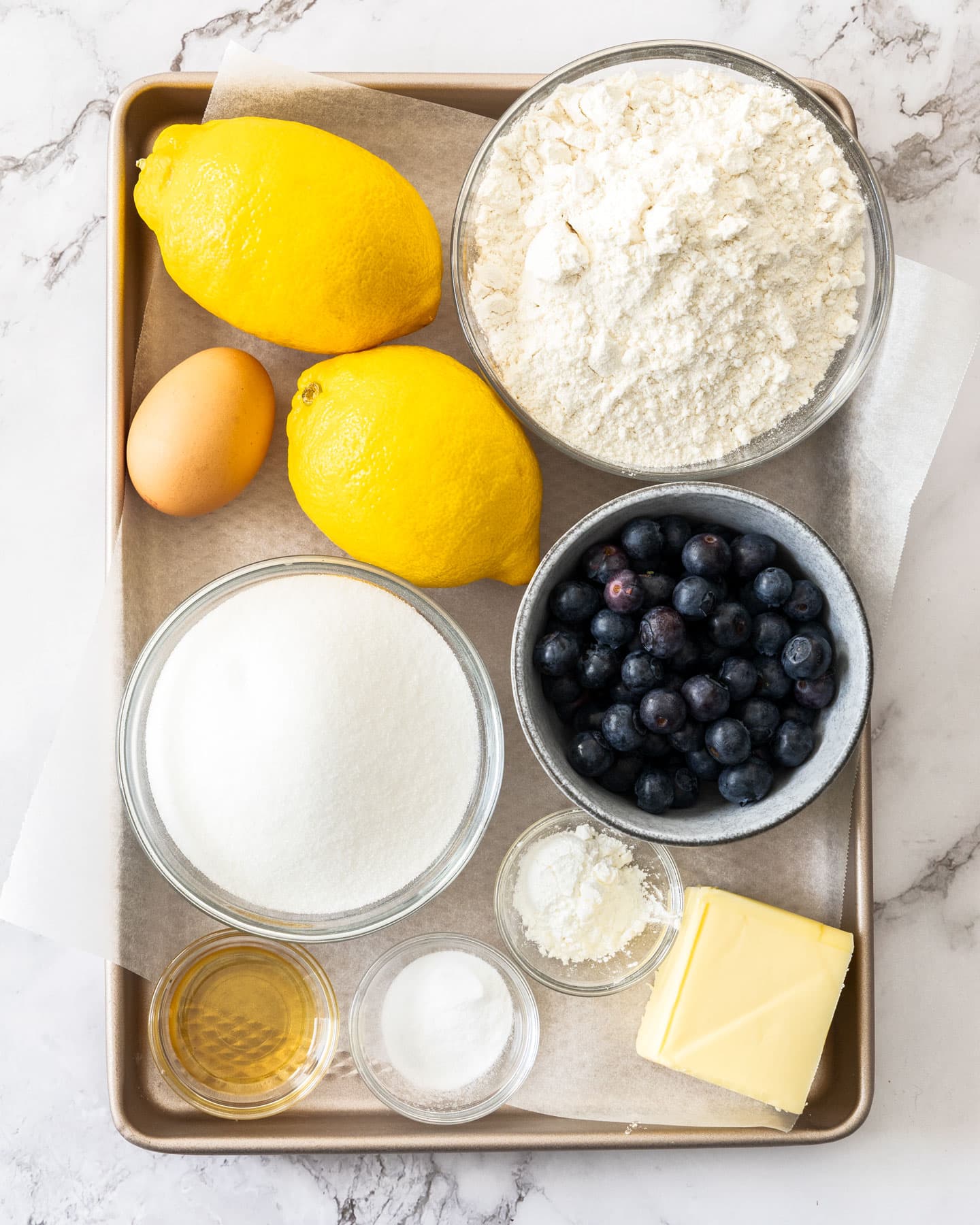 Ingredients for lemon blueberry cookies on a baking tray.